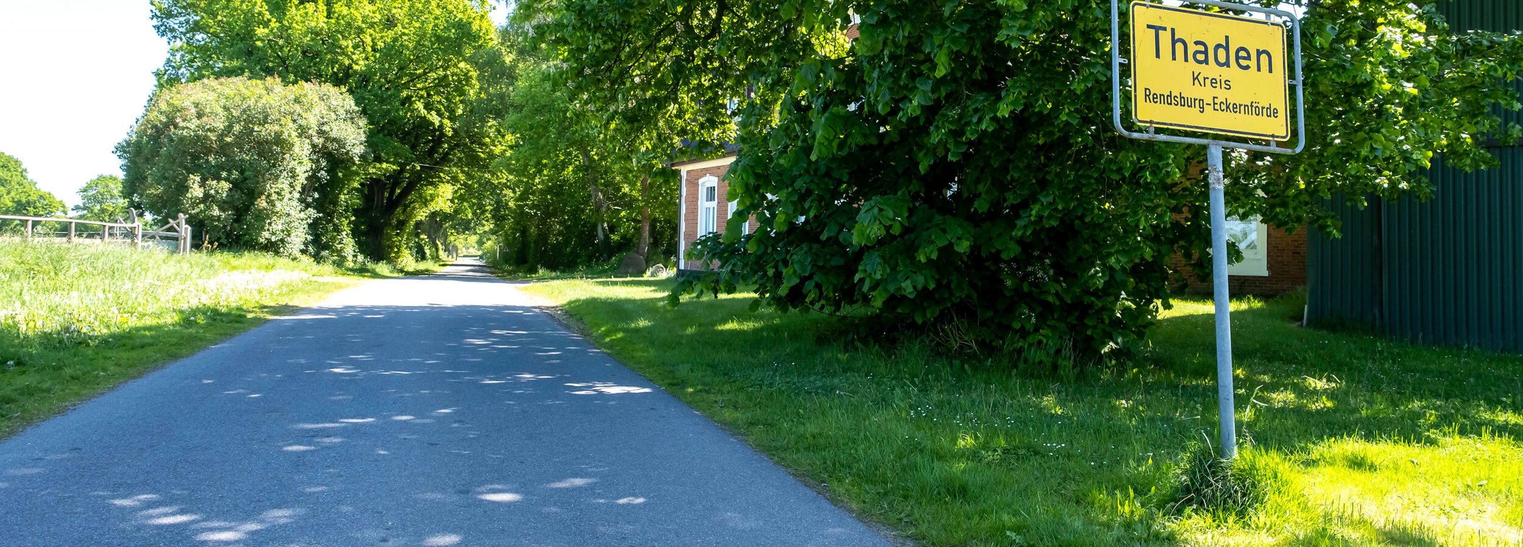 Das Ortsschild der Gemeinde Thaden im Amt Mittelholstein am Straßenrand