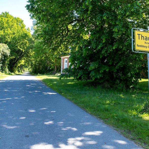 Das Ortsschild der Gemeinde Thaden im Amt Mittelholstein am Straßenrand