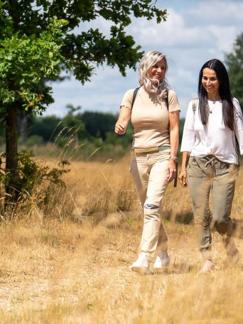 Natürlich entspannen (© sh-tourismus.de/MOCANOX) Zwei Frau wandern durch eine idyllische Naturlandschaft in einem Naturpark.