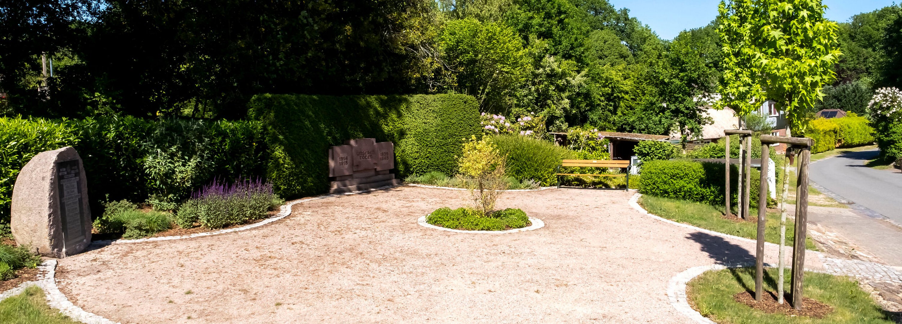 Ehrendenkmal mit grünen Bäumen Gemeinde Grauel im Amt Mittelholstein