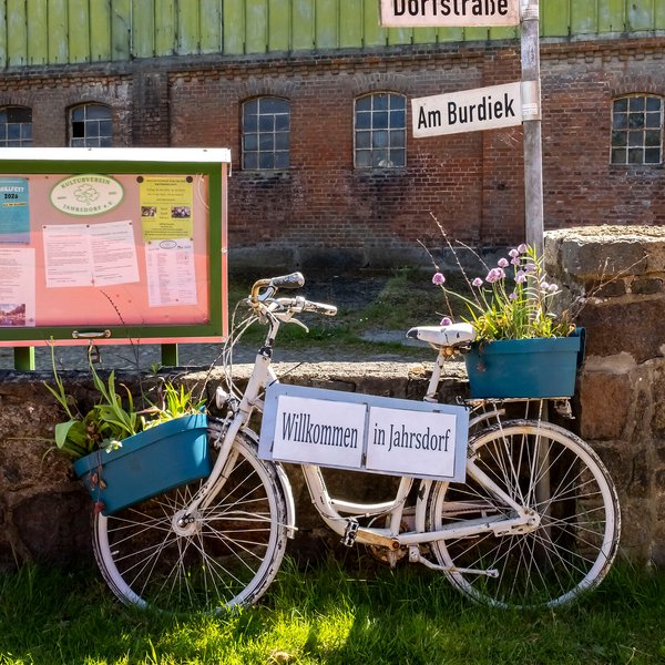 Fahrrad mit einem WIllkommen-Schild in Jahrsdorf