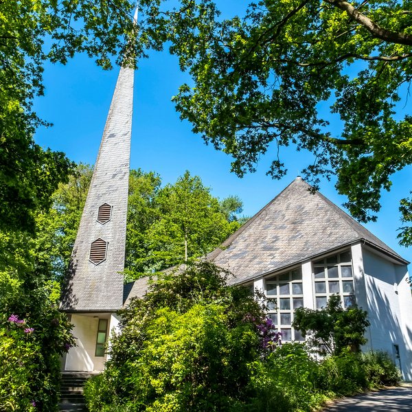 Weiße St. Johanneskirche unter grünen Bäumen in Gokels im Amt Mittelholstein